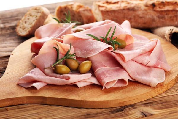 Sliced ham on wooden background. Fresh prosciutto. Pork ham sliced.