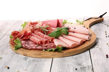 Lezzetli salam, adet dilimlenmiş jambon, sosis ve salata ile yemek tepsisi. Et tabağı ile seçme