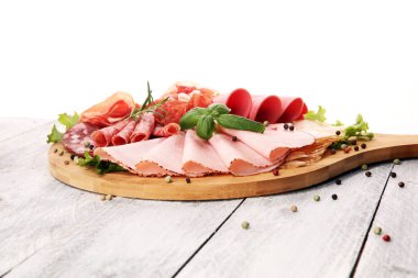 Lezzetli salam, adet dilimlenmiş jambon, sosis ve salata ile yemek tepsisi. Et tabağı ile seçme