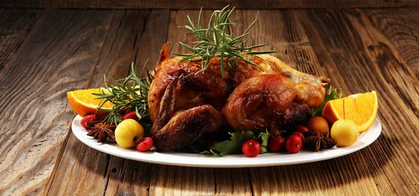 Baked turkey or chicken. The Christmas table is served with a turkey, decorated with fruits, salad and nuts. Fried chicken, table. Christmas dinner.