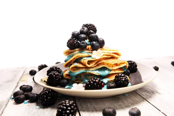 Delicious Tasty Homemade crepes or pancakes with blackberries,blueberries and blue spirulina nicecream