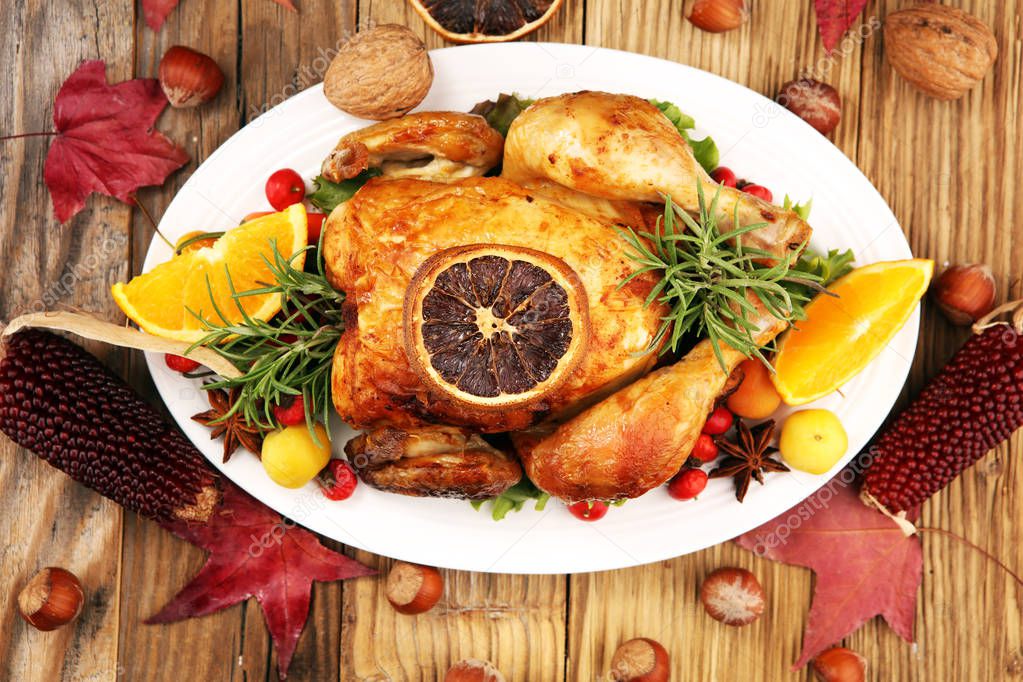 Baked turkey or chicken. The Christmas table is served with a turkey, decorated with fruits, salad and nuts. Fried chicken, table. Christmas dinner. 