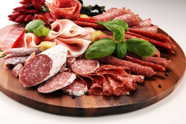 Lezzetli salam, adet dilimlenmiş jambon crudo, sosis ve fesleğen ile yemek tepsisi. Et tabağı ile seçme.