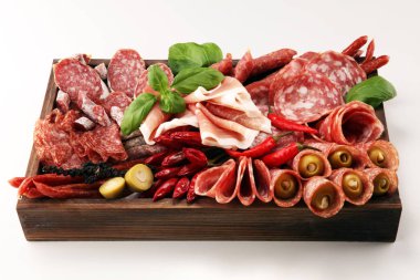 Lezzetli salam, adet dilimlenmiş jambon crudo, sosis ve fesleğen ile yemek tepsisi. Et tabağı ile seçme.