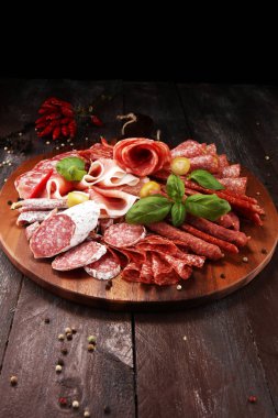 Lezzetli salam, adet dilimlenmiş jambon crudo, sosis ve fesleğen ile yemek tepsisi. Et tabağı ile seçme.