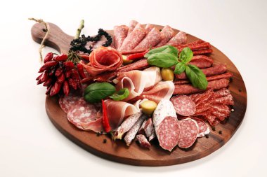 Lezzetli salam, adet dilimlenmiş jambon crudo, sosis ve fesleğen ile yemek tepsisi. Et tabağı ile seçme.