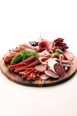 Lezzetli salam, adet dilimlenmiş jambon crudo, sosis ve fesleğen ile yemek tepsisi. Et tabağı ile seçme.