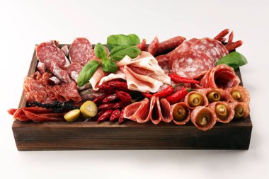 Lezzetli salam, adet dilimlenmiş jambon crudo, sosis ve fesleğen ile yemek tepsisi. Et tabağı ile seçme.