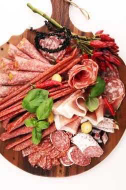 Lezzetli salam, adet dilimlenmiş jambon crudo, sosis ve fesleğen ile yemek tepsisi. Et tabağı ile seçme.