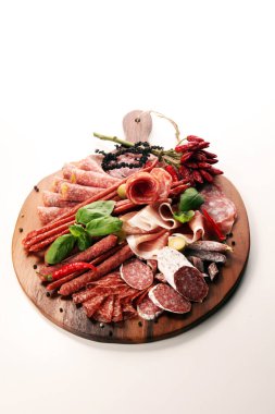 Lezzetli salam, adet dilimlenmiş jambon crudo, sosis ve fesleğen ile yemek tepsisi. Et tabağı ile seçme.