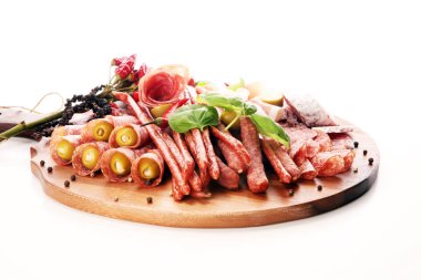 Lezzetli salam, adet dilimlenmiş jambon crudo, sosis ve fesleğen ile yemek tepsisi. Et tabağı ile seçme.
