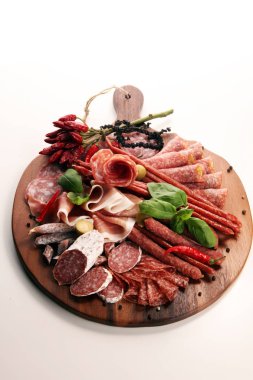 Lezzetli salam, adet dilimlenmiş jambon crudo, sosis ve fesleğen ile yemek tepsisi. Et tabağı ile seçme.