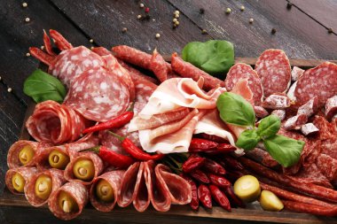 Lezzetli salam, adet dilimlenmiş jambon crudo, sosis ve fesleğen ile yemek tepsisi. Et tabağı ile seçme.