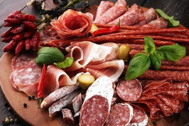 Lezzetli salam, adet dilimlenmiş jambon crudo, sosis ve fesleğen ile yemek tepsisi. Et tabağı ile seçme.
