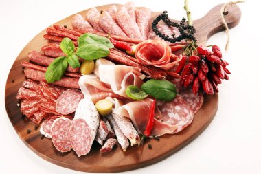 Lezzetli salam, adet dilimlenmiş jambon crudo, sosis ve fesleğen ile yemek tepsisi. Et tabağı ile seçme.