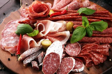 Lezzetli salam, adet dilimlenmiş jambon crudo, sosis ve fesleğen ile yemek tepsisi. Et tabağı ile seçme.