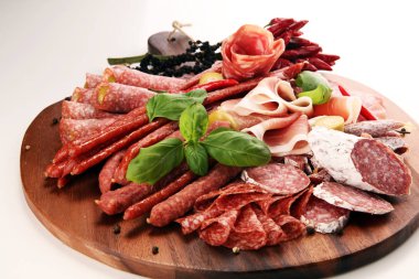 Lezzetli salam, adet dilimlenmiş jambon crudo, sosis ve fesleğen ile yemek tepsisi. Et tabağı ile seçme.