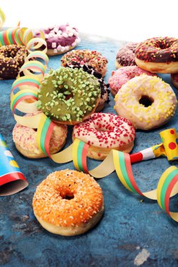 Çikolatalı buzlu, pembe sırlı ve bonibon donuts ile çeşitli çörekler. Karnaval kavramı.