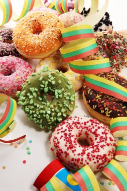 Çikolatalı buzlu, pembe sırlı ve bonibon donuts ile çeşitli çörekler. Karnaval kavramı.