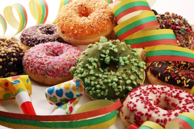 Çikolatalı buzlu, pembe sırlı ve bonibon donuts ile çeşitli çörekler. Karnaval kavramı.