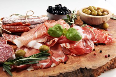 Jambon, pastırma, salam ve sosis ahşap arka plan üzerinde mermer kesme tahtası. Et tabağı meze ve zeytin