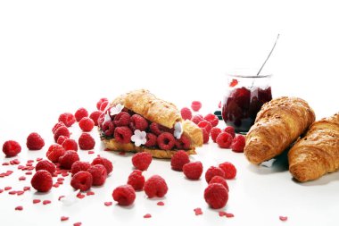 Lezzetli kahvaltı taze kruvasanlar ve olgun çilek ve çiçek ile