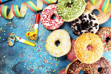 Çikolatalı buzlu, pembe sırlı ve bonibon donuts ile çeşitli çörekler. Karnaval kavramı.