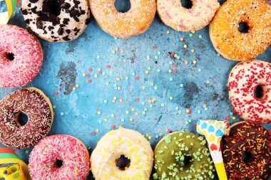 Çikolatalı buzlu, pembe sırlı ve bonibon donuts ile çeşitli çörekler. Karnaval kavramı.