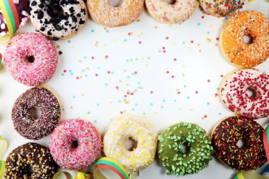 Çikolatalı buzlu, pembe sırlı ve bonibon donuts ile çeşitli çörekler. Karnaval kavramı.