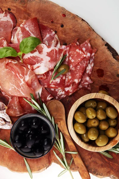 Jambon, pastırma, salam ve sosis ahşap arka plan üzerinde mermer kesme tahtası. Et tabağı meze ve zeytin