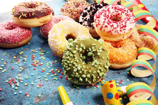 Çikolatalı buzlu, pembe sırlı ve bonibon donuts ile çeşitli çörekler. Karnaval kavramı.