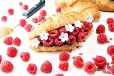 Lezzetli kahvaltı taze kruvasanlar ve olgun çilek ve çiçek ile