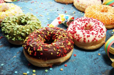 Çikolatalı buzlu, pembe sırlı ve bonibon donuts ile çeşitli çörekler. Karnaval kavramı.