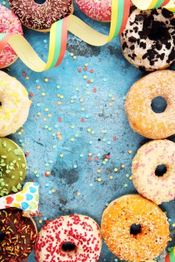 Çikolatalı buzlu, pembe sırlı ve bonibon donuts ile çeşitli çörekler. Karnaval kavramı.