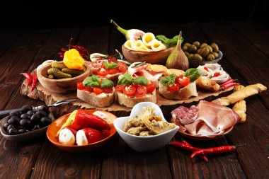 İtalyan antipasti şarap aperatifler küme. Peynir çeşitli, Akdeniz zeytin, turşu, Prosciutto di Parma, domates, enginar masada