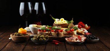 İtalyan antipasti şarap aperatifler küme. Peynir çeşitli, Akdeniz zeytin, turşu, Prosciutto di Parma, domates, enginar ve masada bardaklarda şarap