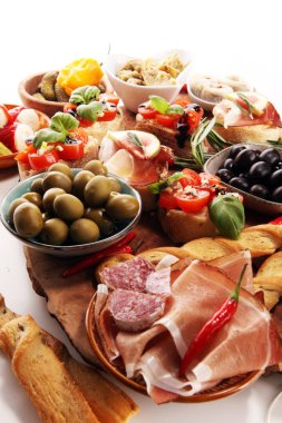 İtalyan antipasti şarap aperatifler küme. Peynir çeşitli, Akdeniz zeytin, turşu, Prosciutto di Parma, domates, enginar ve masada bardaklarda şarap
