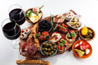 İtalyan antipasti şarap aperatifler küme. Peynir çeşitli, Akdeniz zeytin, turşu, Prosciutto di Parma, domates, enginar ve masada bardaklarda şarap
