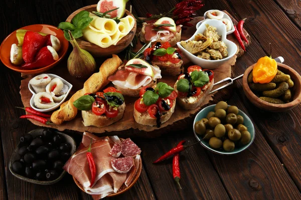 İtalyan antipasti şarap aperatifler küme. Peynir çeşitli, Akdeniz zeytin, turşu, Prosciutto di Parma, domates, enginar masada