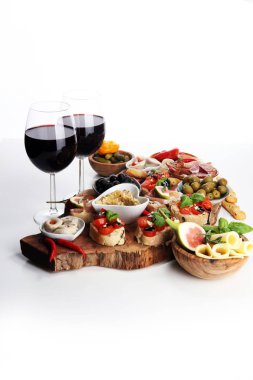 İtalyan antipasti şarap aperatifler küme. Peynir çeşitli, Akdeniz zeytin, turşu, Prosciutto di Parma, domates, enginar ve masada bardaklarda şarap