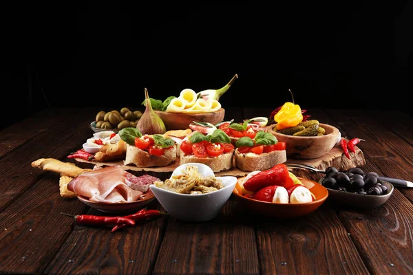 İtalyan antipasti şarap aperatifler küme. Peynir çeşitli, Akdeniz zeytin, turşu, Prosciutto di Parma, domates, enginar masada
