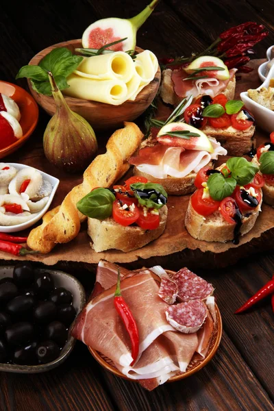 İtalyan antipasti şarap aperatifler küme. Peynir çeşitli, Akdeniz zeytin, turşu, Prosciutto di Parma, domates, enginar masada