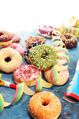 Çikolatalı buzlu, pembe sırlı ve bonibon donuts ile çeşitli çörekler. Karnaval kavramı.