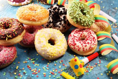 Çikolatalı buzlu, pembe sırlı ve bonibon donuts ile çeşitli çörekler. Karnaval kavramı.