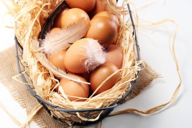Yumurta. Sepet içinde taze çiftlik yumurtaları. Tüy konsepti ile Paskalya yortusu yumurta