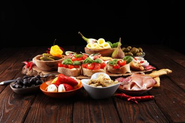 İtalyan antipasti şarap aperatifler küme. Peynir çeşitli, Akdeniz zeytin, turşu, Prosciutto di Parma, domates, enginar masada