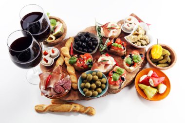 İtalyan antipasti şarap aperatifler küme. Peynir çeşitli, Akdeniz zeytin, turşu, Prosciutto di Parma, domates, enginar ve masada bardaklarda şarap