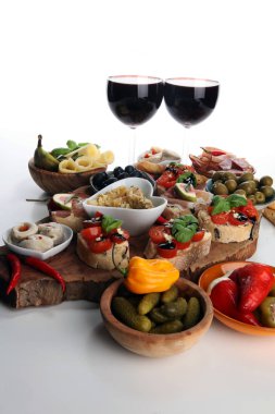 İtalyan antipasti şarap aperatifler küme. Peynir çeşitli, Akdeniz zeytin, turşu, Prosciutto di Parma, domates, enginar ve masada bardaklarda şarap