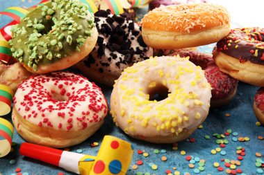 Çikolatalı buzlu, pembe sırlı ve bonibon donuts ile çeşitli çörekler. Karnaval kavramı.