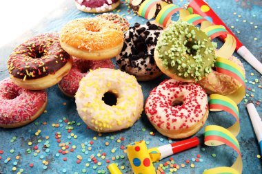 Çikolatalı buzlu, pembe sırlı ve bonibon donuts ile çeşitli çörekler. Karnaval kavramı.